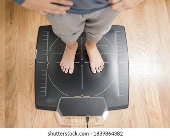 Top View Of A 7 Year Old Boy Standing On A Pressure Plate At The Podiatrist Exam Room, No Faces Are Shown