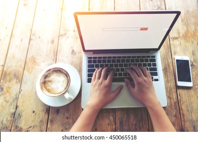 Top View (above) Of Beautiful Young Hipster Woman's Hands Busy Working On Her Laptop Sitting At Wooden Table In A Coffee Shop - Retro Filter Effect And Vintage Color Style