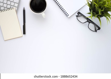 Top View Above Of White Office Desk Table With Keyboard, Notebook And Coffee Cup With Equipment Other Office Supplies. Business And Finance Concept. Workplace, Flat Lay With Blank Copy Space.