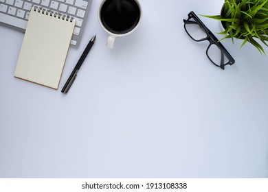 Top View Above Of White Office Desk Table With Keyboard Computer, Notebook And Coffee Cup With Equipment Other Office Supplies. Business And Finance Concept. Workplace, Flat Lay With Blank Copy Space.