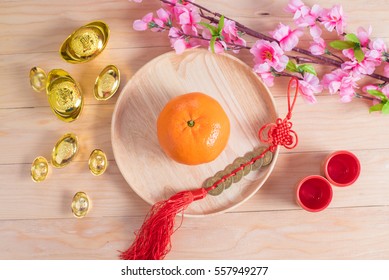 Top view accessories Chinese new year festival decorations.orange,leaf,wood dish,red packet,plum blossom, on wood background