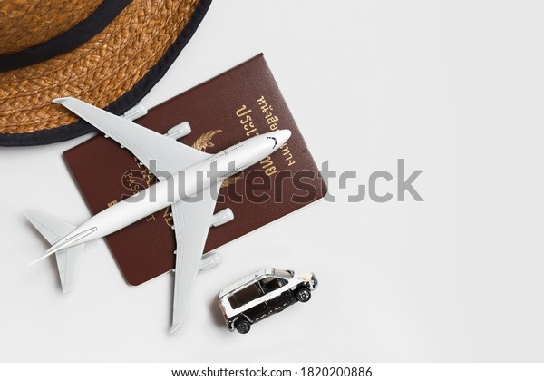 Top view accessory to travel concept with toy white\
car and airplane, passport on white background - Travel objects\
flat lay