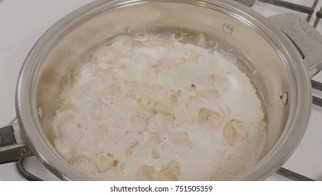 Top view of adding cheese to the pan with the chicken. Chicken frying in a pan. Closeup of chicken meat cooking on a hot pan on a gas stove