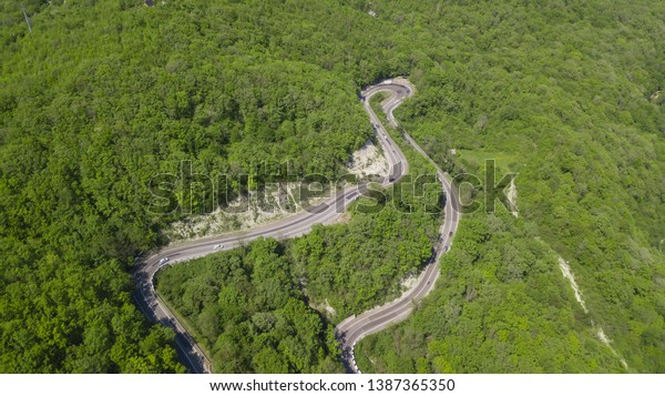 Top view.\
Aerial view from drone. Road in forest is beautiful with many tree,\
road on pass very winding and\
curve