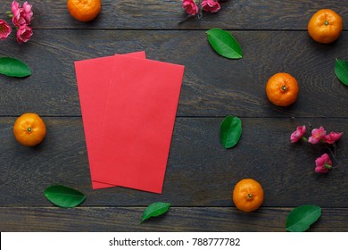 Top view aerial image of accessory decoration Chinese new year & lunar holiday background concept.Flat lay Orange & flower also red pocket money.Variety object on modern brown wood at office desk.