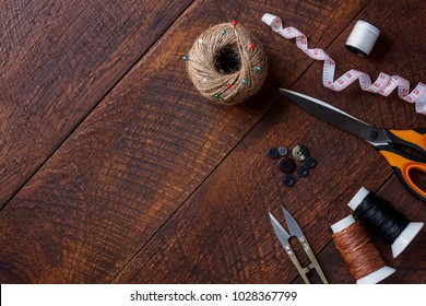 Top view aerial image fashion designer background concept.Flat lay sewing accessory or tailor tool work shop on modern rustic brown wooden at home office desk studio.Space for creative design mock up.
