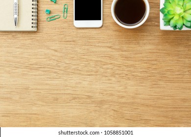 Top View Aerial Image Shot Of Arrangement Accessory Business Background Concept.Flat Lay Smartphone Coffee & Essential Items Pen And Notebook With Plant In Pot On  Wooden Table At Home Office Desk.