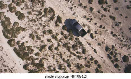 Top View Aerial Photo From Drone Of Farmer Pickup Machine Riding In Texas Rural For Check His Farmland. Journey To America On Rental Car In Desert Valley Landscape. Beautiful Photo For Travel Website