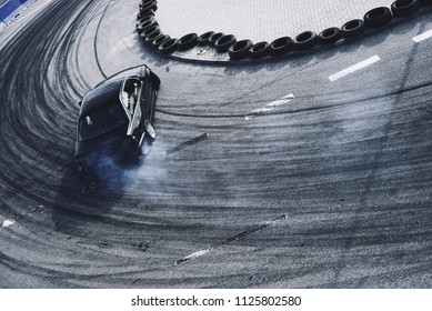 Top view aerial photo from flying drone of a professional driver drifting car on asphalt track. - Shutterstock ID 1125802580