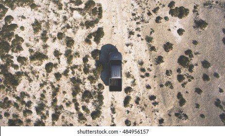 Top View Aerial Photo From Flying Drone Of A Silver Pickup Machine Is Riding In A Steppe With Green Plants In Sunny Day. Sport Recreation With Rental Car In Countryside During Summer Trip To America