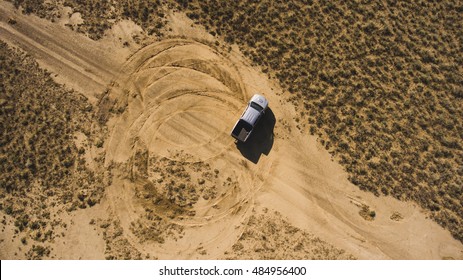 Top View Aerial Photo From Flying Drone Of A Professional Driver Having Dangerous Ride With Pickup Car In Desert Landscape. Active Extreme Sport Leisure With Automobile In Arid Steppe In Sunny Day