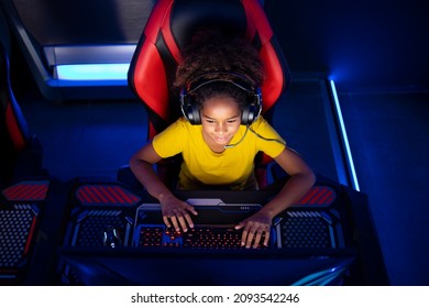 Top View Of African American Girl Gamer Playing Video Games On Computer In Game Room. Children's Addiction To Virtual Games And Entertainment.