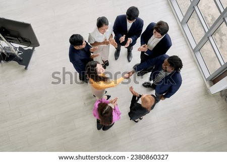 Top view of Agree or Commitment with hand shake by business team in seminar office room and other people crap the hand for celebrate this action.