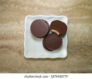 Top View Of Almond Butter Chocolate Cups On A White Plate.