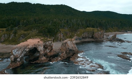 Top view of amazing coast with rocks and erosion. Clip. Through rocks with flying gulls on seashore. Fantastic landscape with rocks and seagulls on shore of North Sea on cloudy day - Powered by Shutterstock