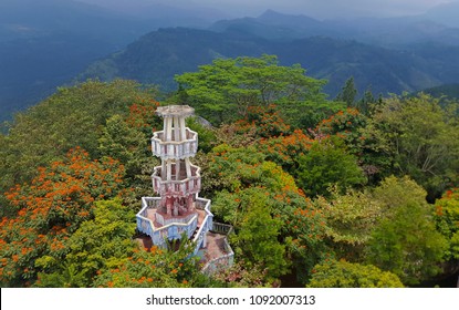 Top view of the Ambuluwawa multi religious tower situated amidst the blooming Flame trees in Gampola, Sri Lanka.