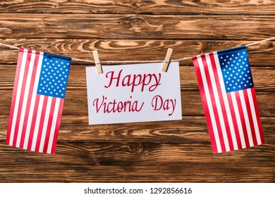 top view of american flags and card with 'happy victoria day' lettering on wooden background - Shutterstock ID 1292856616