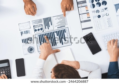 Top view analyst team utilizing BI Fintech to analyze financial data at table in meeting room. Analytic BI dashboard power on paper for business insight and strategic marketing planning. Prudent