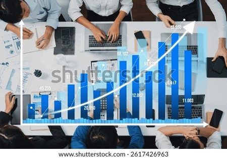 Top view analyst team utilizing BI Fintech to analyze financial data at table in meeting room. Analytic BI dashboard power on paper for business insight and strategic marketing planning. Prudent Amity