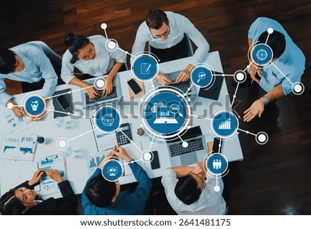 Top view analyst team utilizing BI Fintech to analyze financial data at table in meeting room. Analytic BI dashboard power on paper for business insight and strategic marketing planning. Prudent Amity