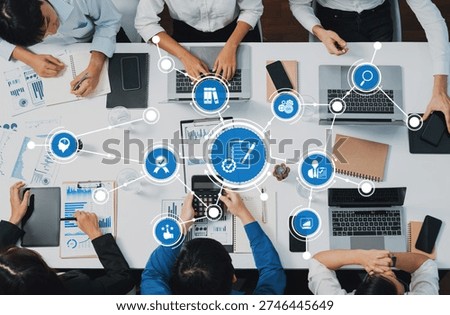 Top view analyst team utilizing BI Fintech to analyze financial data at table in meeting room. Analytic BI dashboard power on paper for business insight and strategic marketing planning. Prudent Amity