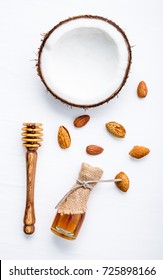 Top View Angle Of Coconut Almond And Honey On White Wooden Background. Coconut Almond Milk Ingredients. Easy And Healthy Drink With High Vitamins B And E.Tasty Natural Drink For Smoothies And Granola