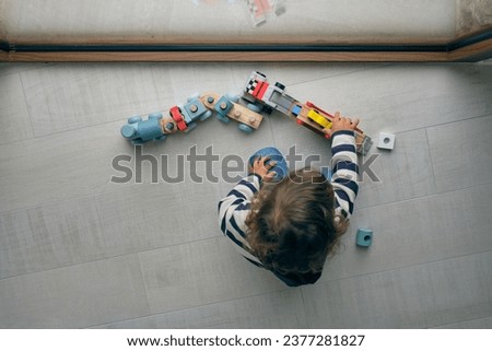 Similar – Baby Mädchen spielt mit Haarspangen, die auf dem Boden liegen.