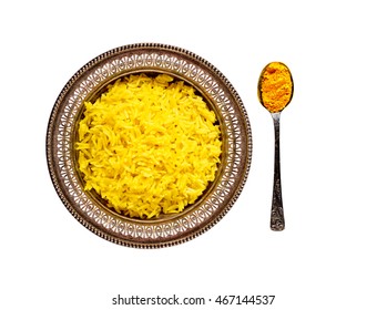 Top view of an antique metal bowl with cooked turmeric jasmine rice and vintage metal teaspoon with powdered curcumin isolated on white