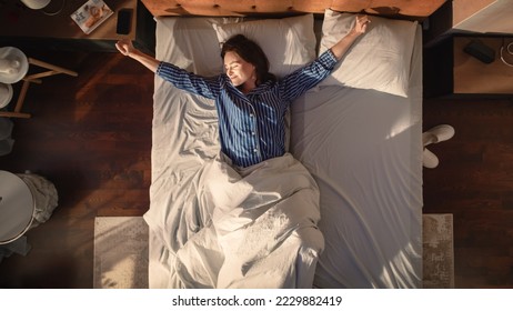 Top View Apartment: Beautiful Young Woman Sleeps Charmingly in Her Bed, Turns off Smartphone Alarm Clock, Greets a New Day with Happiness and Smiles. Top Down - Powered by Shutterstock