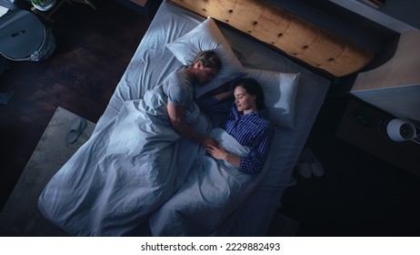 Top View Apartment: Happy Young Couple Sleeping in Bed at Night. Beautiful Girlfriend and Handsome Boyfriend Sleeping Together. Family of two Sweetly Sleeping Facing Each other. - Powered by Shutterstock