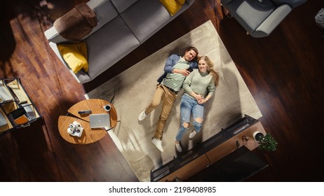 Top View Apartment: Young Couple In Love Lying On The Floor And Talking, Sharing Their Dreams, Aspirations And Hopes. Girlfriend And Boyfriend Planning Brighter Future Together In A Cozy Living Room