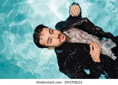 Top View Of Arabian Businessman In Suit Swimming In Pool With Light