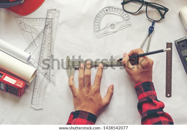 Top View Architect\
working on blueprint. Architects workplace. Engineer tools and\
safety control, blueprints, ruler, radio, laptop and divider\
compass. Construction\
Concept.