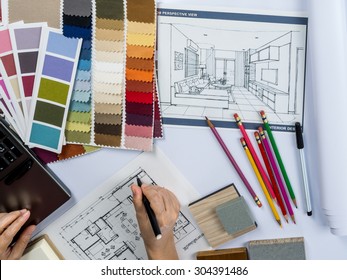 Top view of architects hands drawing of modern house with material sample on creative desk - Shutterstock ID 304391486