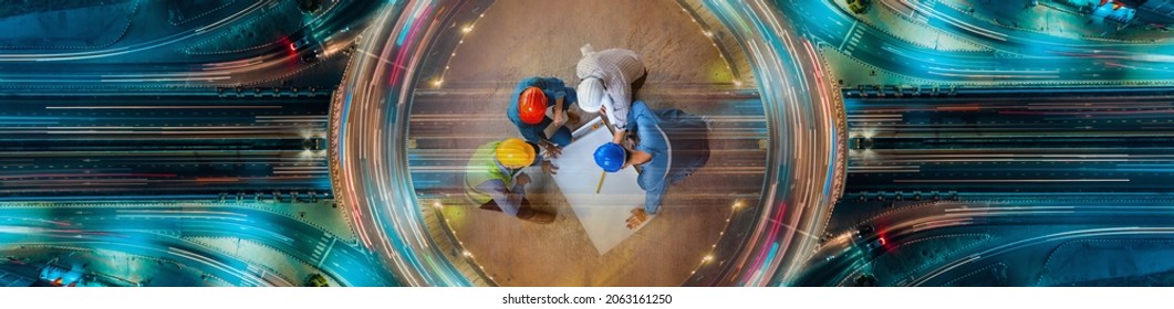 Top view of architectural engineer working on his blueprints with documents on construction site. meeting, discussing,designing, planing. Road traffic an important infrastructure