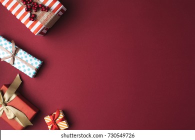top view of arranged wrapped christmas gift boxes with ribbons on red tabletop
