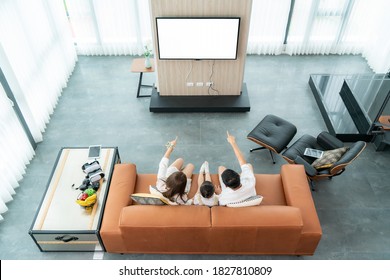 Top View Of Asian Happy Family Sitting And Watching Television In Living Room At Home And Spent Quality Time Together For Activity In Vacation Day, Holiday, Happiness Or Lifestyle Concept.
