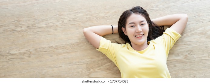 Top View Of Asian Woman Looking Camera Happy Resting Clam And Like A Sleeping Lying Down On Wooden Floor With Copy Space In Banner Size For Cover Template Website