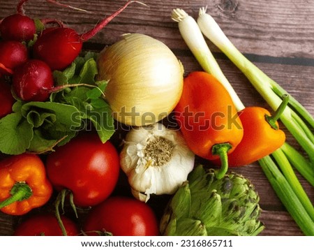 Top view. Assorted vegetables from above. Radishes, onions, peppers, garlic, tomatoes, artichoke. Fresh produce. Harvest. Agriculture. Nutrition. Diet. Healthy eating. Vegetarian. Vegan. Organic.