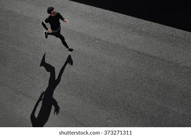 Top View Athlete Runner Training At Road In Black Sportswear At Central Position. Man Running On Country Road, Healthy Inspirational Fitness Lifestyle, Sport Motivation Speed Interval Training. 