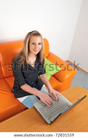 Similar – Entrepreneur woman wearing red shirt working with a laptop sitting on a couch at home