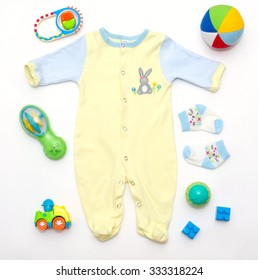 Top View Of Baby Boy Yellow-blue Clothes And Toy Stuff