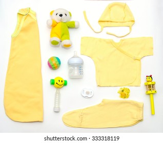 Top View Of Baby Girl Yellow Clothes And Toy Stuff