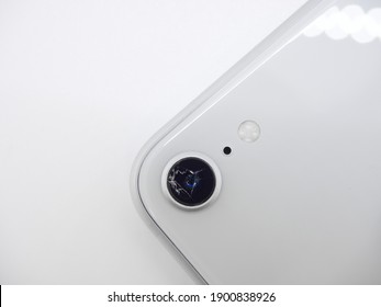 Top View The Back Of White Modern Smartphone With A Broken Camera Glass Close-up Isolated On White Background