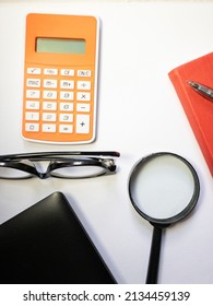 Top View Background Of Workplace With Notebook, Pen , Glasses, Calculator, ,magnifying Glass And Lap Top On  White  Background . Business Concept Mockup