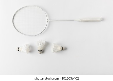 top view of badminton racket with suttercocks in row on white surface