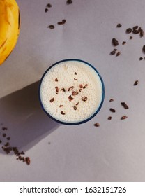 Top view of a banana smoothie with cacao nibs.