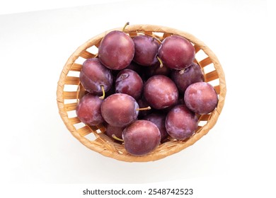 Top view of basket with plums isolated on white.