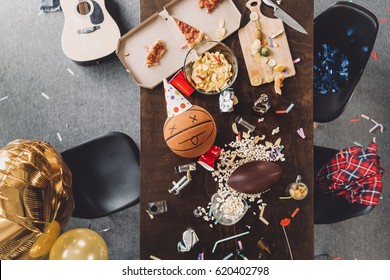 Top View Of Basketball Ball With Funny Face On Messy Table After Party 