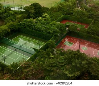 Top view of basketball and tennis courts surrounded by trees